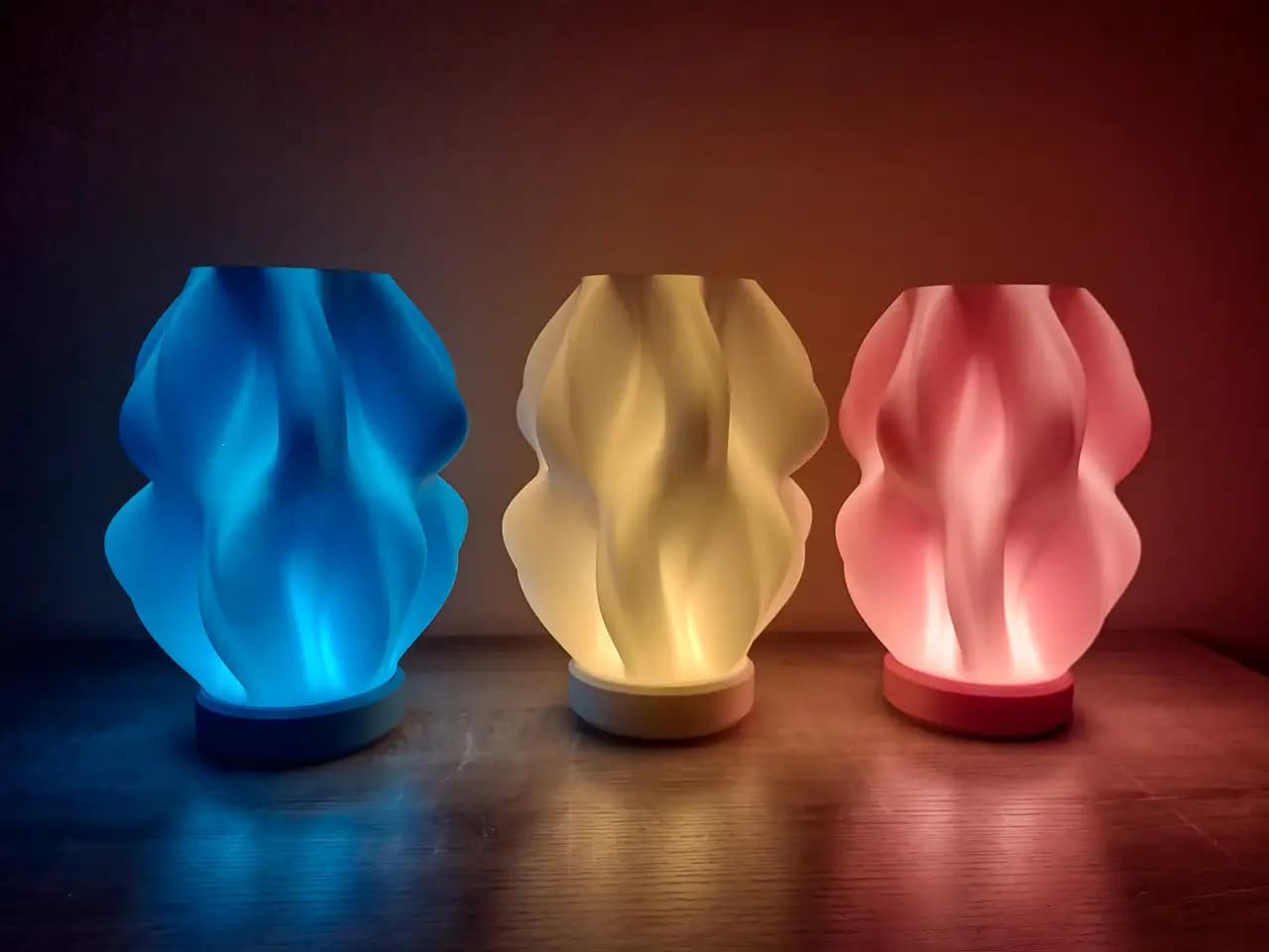 3D-printed lamps glowing in blue, warm white, and red